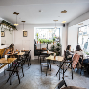 Image of a cafe with plenty of seating, bright light and a cozy, relaxed vibe